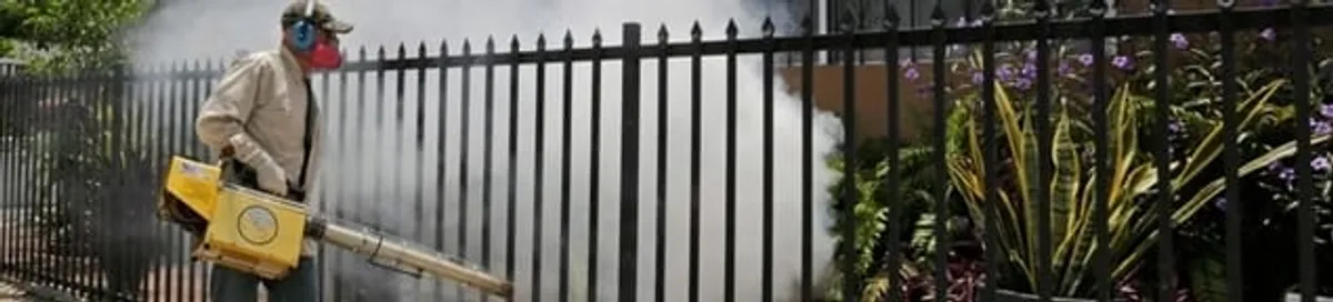 Mosquito control technician fogging a yard perimeter for mosquito reduction in Milwaukee, WI